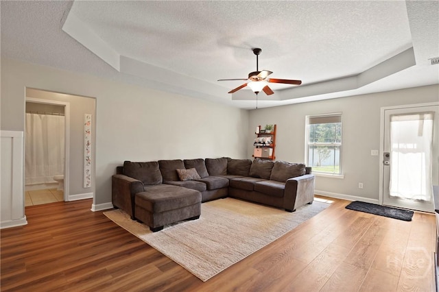 541 Deloach Rd NE, Ludowici, GA 31316 - living room with a raised ceiling, a textured ceiling, wood finished floors, ceiling fan, and baseboards