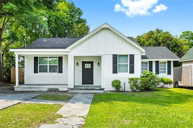 1825 Lloyd St, Savannah, GA 31405 - view of front of home with board and batten siding, a front lawn, roof with shingles, and a porch
