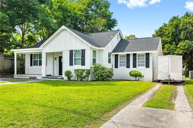 1825 Lloyd St, Savannah, GA 31405 - view of front of home featuring dirt driveway, board and batten siding, a shingled roof, and a front yard