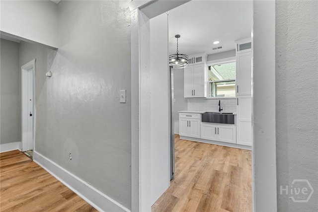 1825 Lloyd St, Savannah, GA 31405 - corridor featuring a sink, light wood-style floors, baseboards, a textured wall, and recessed lighting