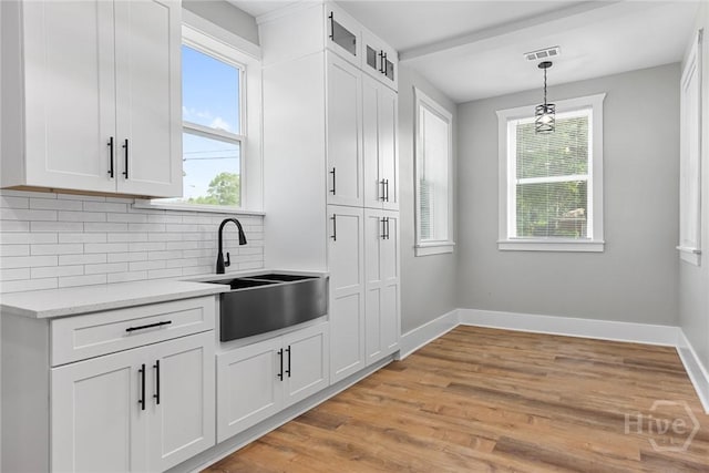 1825 Lloyd St, Savannah, GA 31405 - kitchen with a sink, decorative backsplash, baseboards, and light wood finished floors