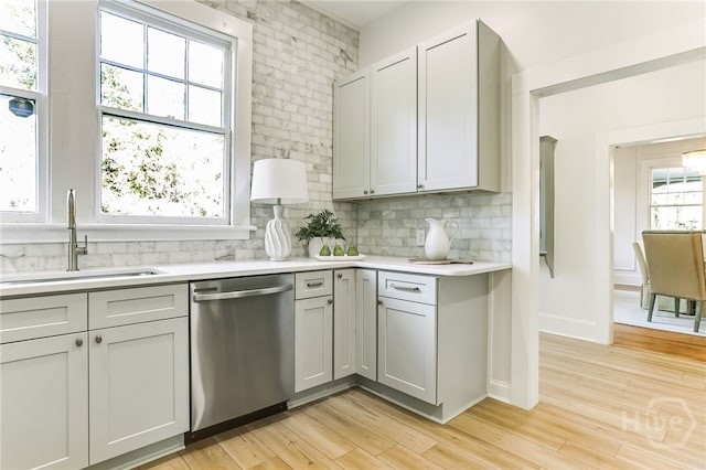 1001 Maupas Ave, Savannah, GA 31401 - kitchen with stainless steel dishwasher, a sink, light countertops, tasteful backsplash, and light wood-style flooring