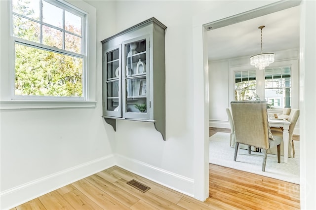 1001 Maupas Ave, Savannah, GA 31401 - dining room featuring a chandelier, baseboards, and light wood-type flooring