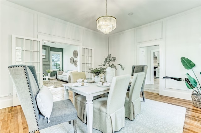 1001 Maupas Ave, Savannah, GA 31401 - dining space featuring a chandelier, a decorative wall, and light wood-style floors