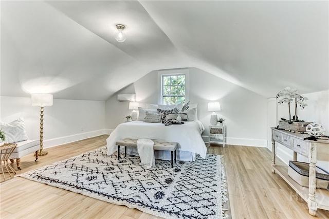1001 Maupas Ave, Savannah, GA 31401 - bedroom with wood finished floors, a wall unit AC, vaulted ceiling, and baseboards