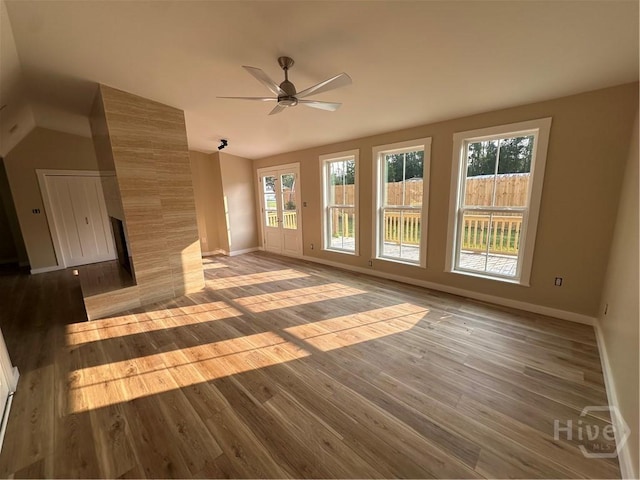 40 Circle Dr, Pembroke, GA 31321 - unfurnished living room with wood finished floors, ceiling fan, vaulted ceiling, and a tiled fireplace