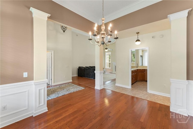 201 Henderson Oaks Dr, Savannah, GA 31419 - unfurnished dining area with a chandelier, light wood-style floors, ornate columns, and ornamental molding