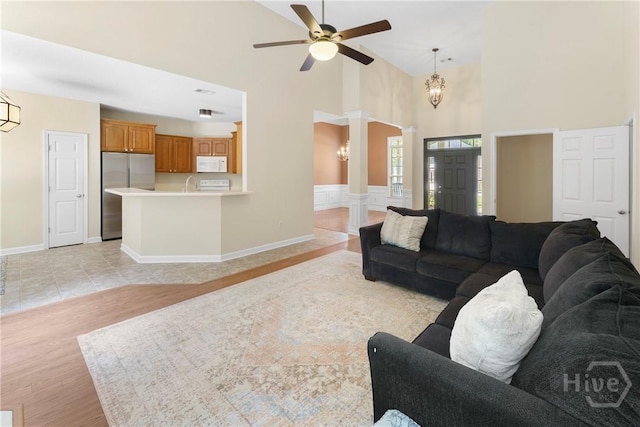 201 Henderson Oaks Dr, Savannah, GA 31419 - living room with ornate columns, a ceiling fan, high vaulted ceiling, light wood-type flooring, and a chandelier
