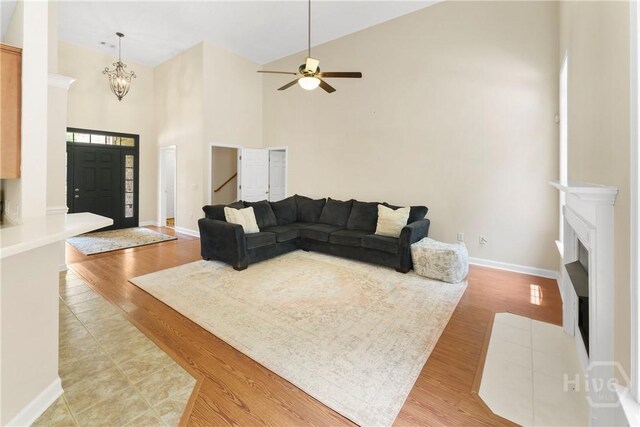 201 Henderson Oaks Dr, Savannah, GA 31419 - living area with high vaulted ceiling, baseboards, light wood-type flooring, ceiling fan, and a fireplace
