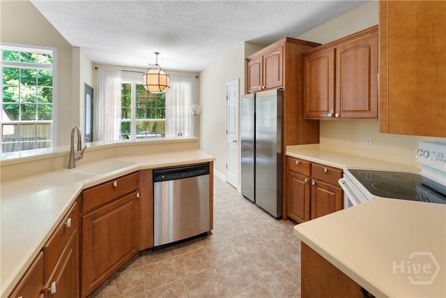 201 Henderson Oaks Dr, Savannah, GA 31419 - kitchen with appliances with stainless steel finishes, a sink, brown cabinets, a textured ceiling, and hanging light fixtures