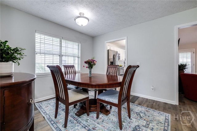 19 S Lake Dr, Savannah, GA 31410 - dining room featuring light wood-style floors, plenty of natural light, baseboards, and a textured ceiling