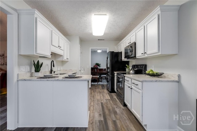 19 S Lake Dr, Savannah, GA 31410 - kitchen featuring black appliances, a sink, a textured ceiling, white cabinets, and wood finished floors