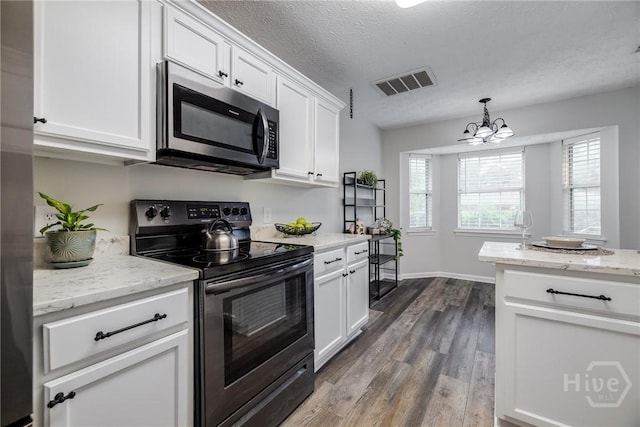 19 S Lake Dr, Savannah, GA 31410 - kitchen featuring stainless steel microwave, black range with electric stovetop, dark wood finished floors, white cabinets, and a chandelier