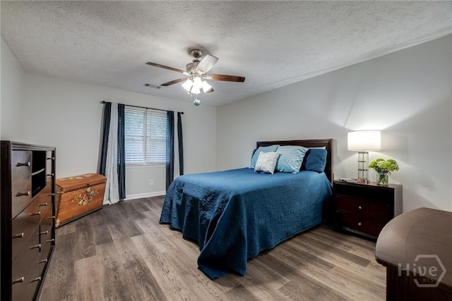 19 S Lake Dr, Savannah, GA 31410 - bedroom with wood finished floors, a textured ceiling, a ceiling fan, and baseboards