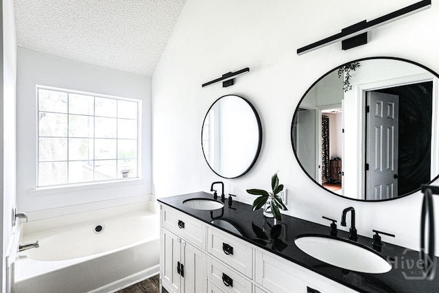 111 Runner Rd, Savannah, GA 31410 - bathroom with a garden tub, a textured ceiling, double vanity, wood finished floors, and vaulted ceiling