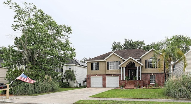 111 Runner Rd, Savannah, GA 31410 - split foyer home with brick siding, concrete driveway, an attached garage, a front yard, and stucco siding