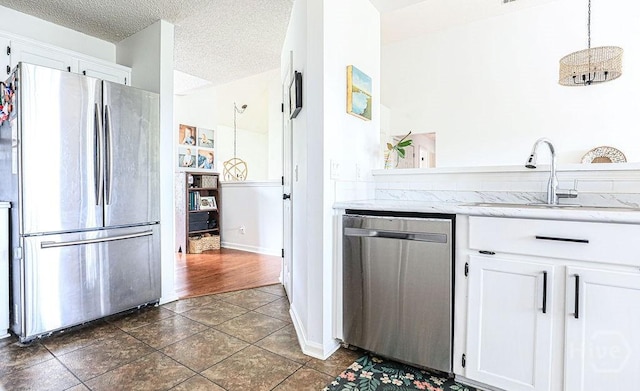 111 Runner Rd, Savannah, GA 31410 - kitchen with appliances with stainless steel finishes, a sink, white cabinets, a textured ceiling, and dark tile patterned floors
