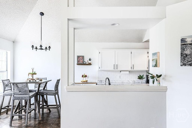 111 Runner Rd, Savannah, GA 31410 - kitchen featuring a textured ceiling, tasteful backsplash, white cabinets, a chandelier, and light countertops