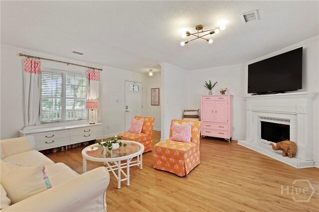5109 Laroche Ave, Savannah, GA 31404 - living area with light wood-style flooring, a brick fireplace, and a textured ceiling