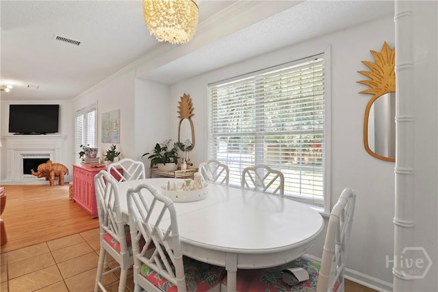 5109 Laroche Ave, Savannah, GA 31404 - dining space with crown molding, a fireplace, and light tile patterned floors