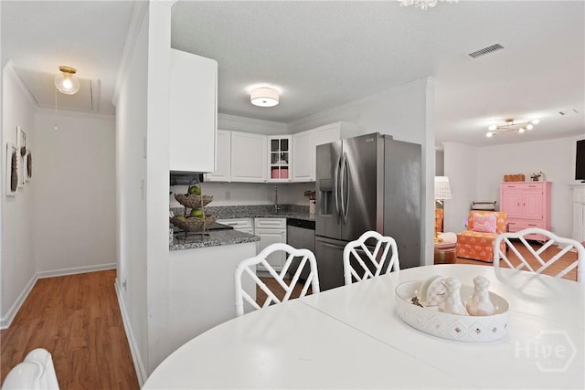 5109 Laroche Ave, Savannah, GA 31404 - kitchen featuring stainless steel appliances, white cabinetry, glass insert cabinets, light wood-style flooring, and baseboards