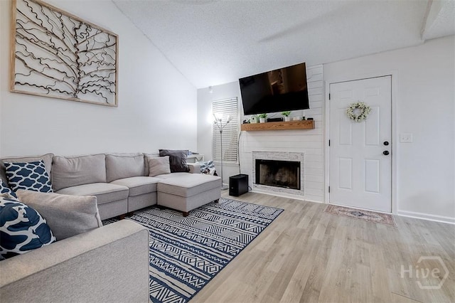 5 Sugar Cane Dr, Savannah, GA 31419 - living room with wood finished floors, vaulted ceiling, a fireplace, and a textured ceiling
