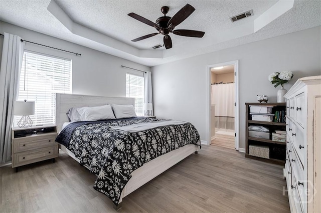 5 Sugar Cane Dr, Savannah, GA 31419 - bedroom with a tray ceiling, a textured ceiling, light wood finished floors, and baseboards