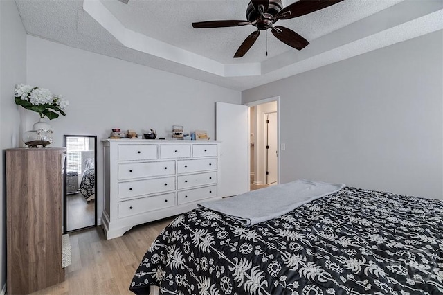 5 Sugar Cane Dr, Savannah, GA 31419 - bedroom with a tray ceiling, a textured ceiling, light wood-style flooring, and ceiling fan