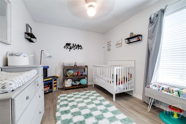 5 Sugar Cane Dr, Savannah, GA 31419 - bedroom featuring light wood-type flooring, a ceiling fan, baseboards, and a nursery area