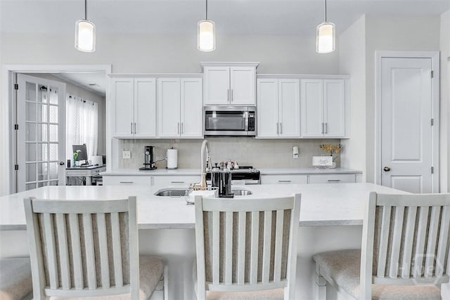 214 Park Chase Chase, Pooler, GA 31322 - kitchen featuring appliances with stainless steel finishes, an island with sink, tasteful backsplash, a sink, and light countertops