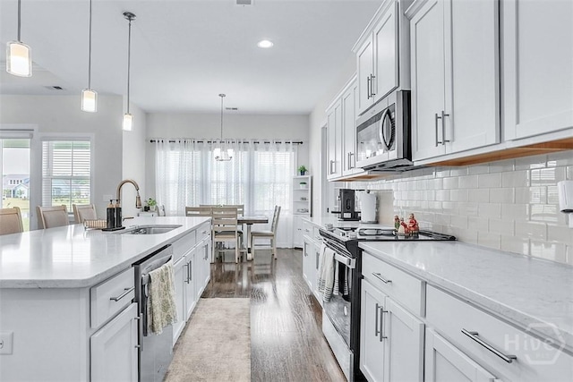 214 Park Chase Chase, Pooler, GA 31322 - kitchen featuring appliances with stainless steel finishes, a sink, wood finished floors, decorative backsplash, and an island with sink