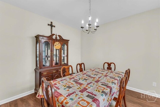 413 Lions Den Dr, Pooler, GA 31322 - dining room featuring a chandelier, dark wood-style flooring, and baseboards