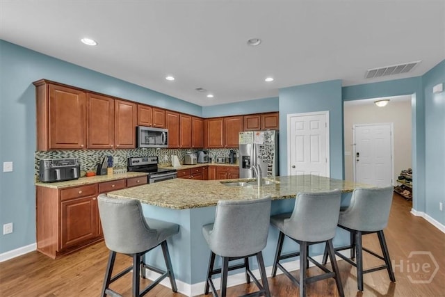 413 Lions Den Dr, Pooler, GA 31322 - kitchen with stainless steel appliances, a sink, a kitchen bar, baseboards, and backsplash