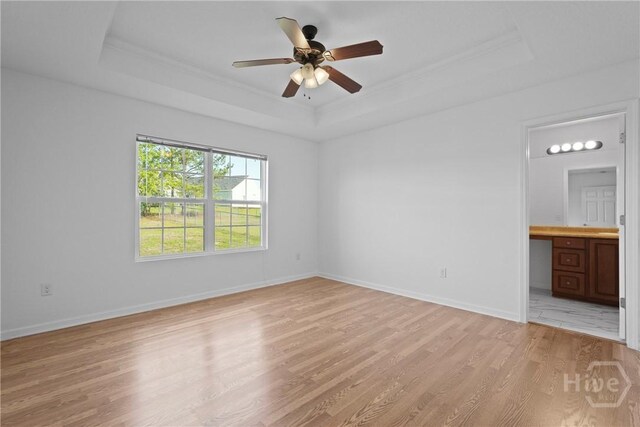 315 S Bridgeport Dr, Statesboro, GA 30461 - unfurnished bedroom with a tray ceiling, light wood-style floors, ornamental molding, baseboards, and connected bathroom