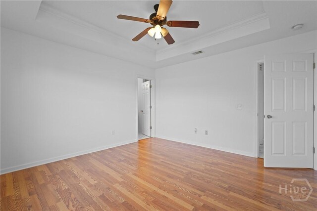 315 S Bridgeport Dr, Statesboro, GA 30461 - empty room featuring a raised ceiling, ornamental molding, light wood-type flooring, a ceiling fan, and baseboards