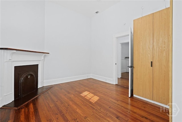 710 W 36th St, Savannah, GA 31415 - unfurnished living room with hardwood / wood-style floors, a fireplace with raised hearth, and baseboards