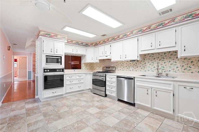 145 Cardinal Rd, Savannah, GA 31406 - kitchen featuring appliances with stainless steel finishes, a sink, light countertops, white cabinets, and under cabinet range hood