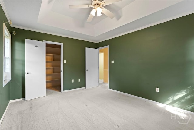 145 Cardinal Rd, Savannah, GA 31406 - unfurnished bedroom featuring carpet, a tray ceiling, a walk in closet, baseboards, and crown molding