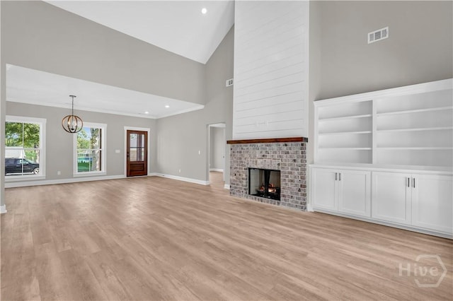 1362 Ebenezer Rd, Rincon, GA 31326 - unfurnished living room with light wood-style flooring, a chandelier, baseboards, a fireplace, and high vaulted ceiling