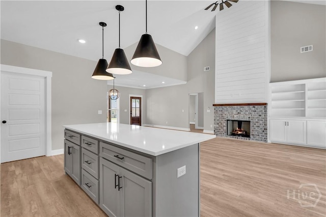 1362 Ebenezer Rd, Rincon, GA 31326 - kitchen with gray cabinets, high vaulted ceiling, light wood finished floors, a center island, and light countertops