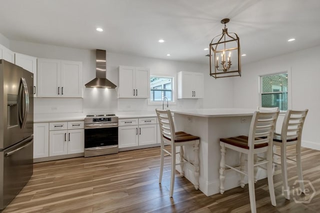 238-A W Magnolia Ave, Savannah, GA 31419 - kitchen featuring stainless steel appliances, wall chimney exhaust hood, light wood-style flooring, light countertops, and recessed lighting