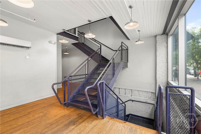 301 W Broughton St Unit 3B, Savannah, GA 31401 - stairway with a wall mounted air conditioner, plenty of natural light, wood finished floors, and a wall of windows