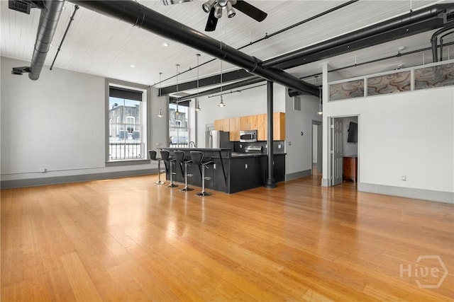 301 W Broughton St Unit 3B, Savannah, GA 31401 - living area with a ceiling fan, light wood-style floors, baseboards, and a high ceiling