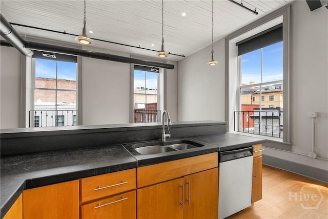 301 W Broughton St Unit 3B, Savannah, GA 31401 - kitchen featuring stainless steel dishwasher, a sink, light wood-type flooring, dark countertops, and pendant lighting