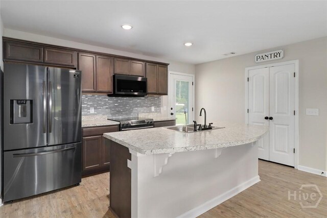 304 Boomer Ct, Guyton, GA 31312 - kitchen featuring stainless steel appliances, a sink, light countertops, dark brown cabinetry, and light wood-type flooring