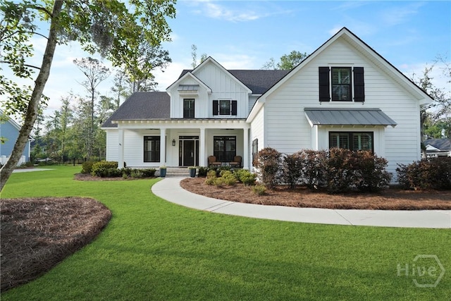 315 Linkside Lake Dr, Richmond Hill, GA 31324 - modern farmhouse featuring board and batten siding, covered porch, a front yard, and a standing seam roof