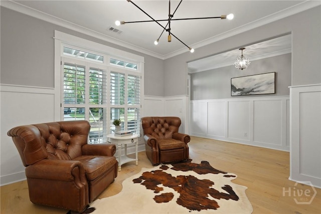 315 Linkside Lake Dr, Richmond Hill, GA 31324 - sitting room with a chandelier, a decorative wall, crown molding, light wood finished floors, and wainscoting