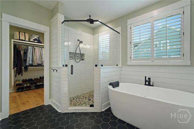 315 Linkside Lake Dr, Richmond Hill, GA 31324 - full bath with a freestanding tub, a stall shower, a walk in closet, and tile patterned flooring