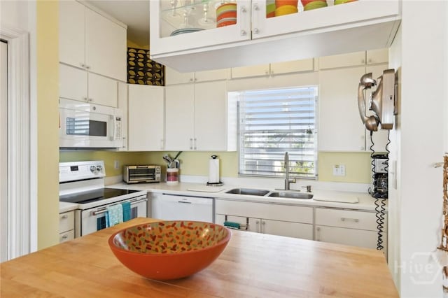 5 Northshore Dr, Tybee Island, GA 31328 - kitchen with white appliances, a sink, and white cabinetry