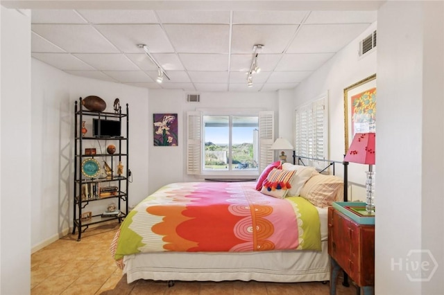 5 Northshore Dr, Tybee Island, GA 31328 - bedroom featuring rail lighting, a paneled ceiling, and tile patterned floors